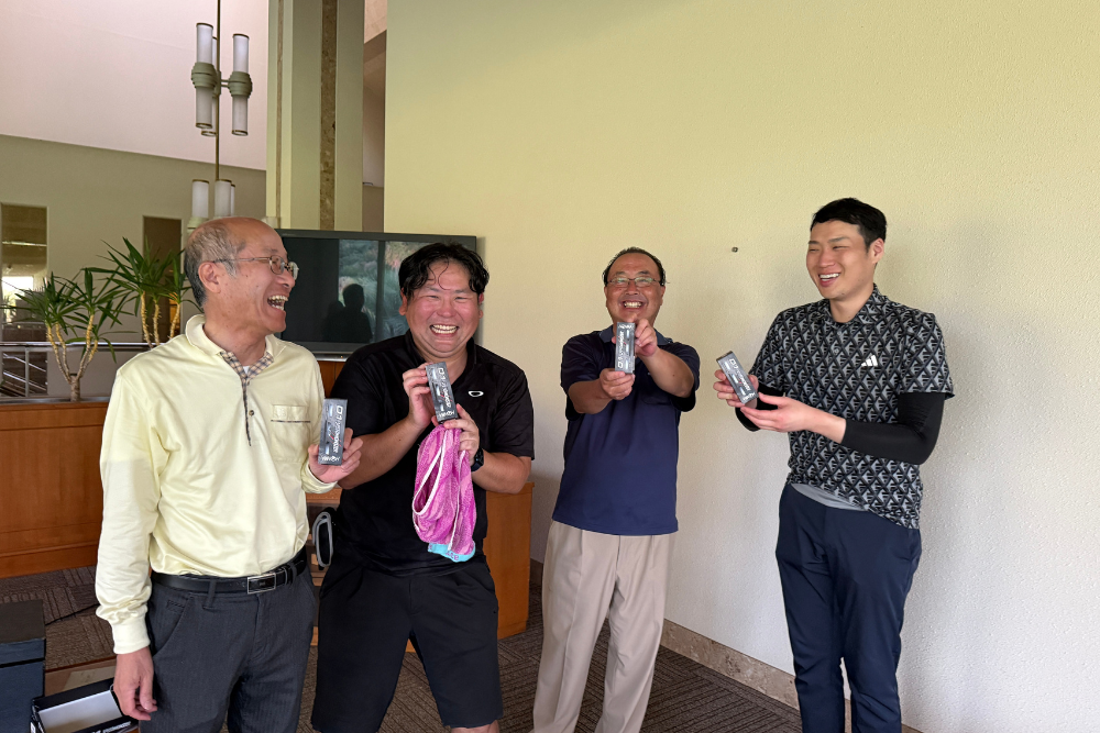 ゴルフコンペ終了後に楽しく話す様子